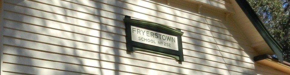 The Fryerstown School No. 252 sign mounted on the cream weatherboard gable of the building